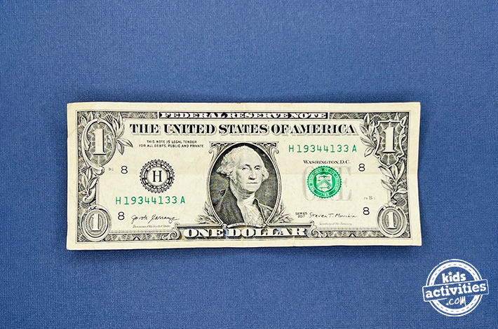 Pantalon origami en forme de billet d'un dollar - Étape 1 - Dépliez-le doucement pour créer un pli net.