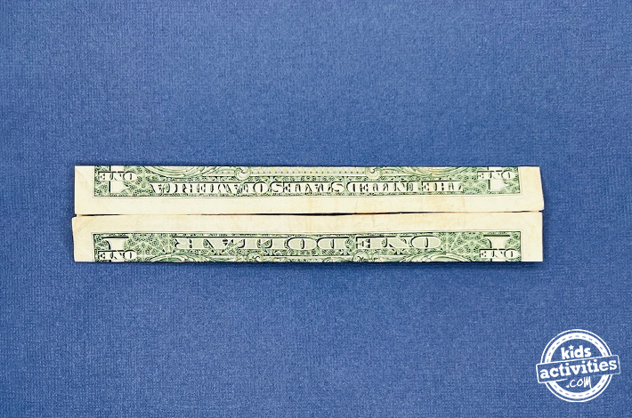 Pantalon origami en forme de billet d'un dollar - Étape 2 - Avancez les bords supérieur et inférieur vers le pli central formé à l'étape précédente.