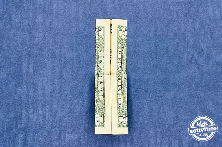 Pantalon origami en forme de billet d'un dollar - Étape 6 - Pliez la couche supérieure vers le bas, en laissant un rabat triangulaire en dessous. Retournez la forme et répétez cette étape de l’autre côté de la facture.