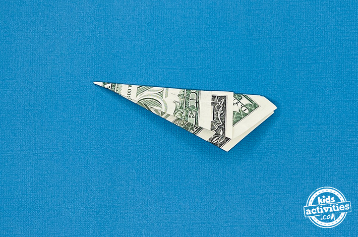 Cygne en origami en forme de billet d'un dollar - Étape 4 - Pliez la figurine en deux le long du pli existant. Tutoriel du blog d'activités pour enfants.