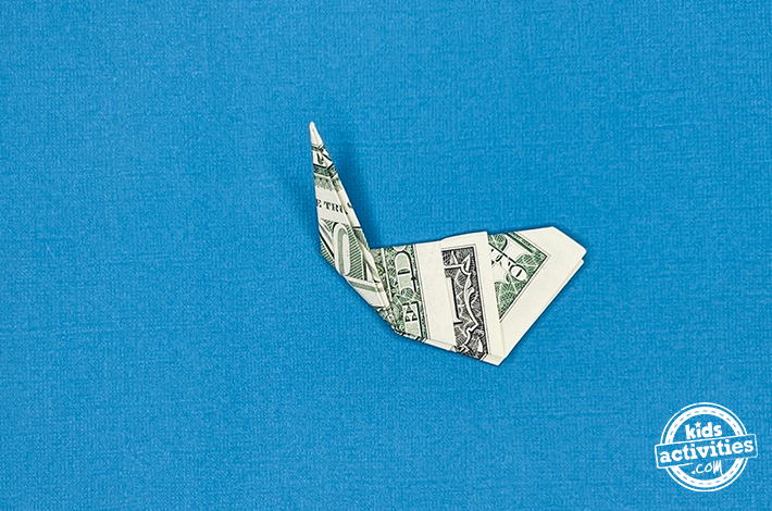 Cygne en origami en forme de billet d'un dollar - Étape 5 - Pliez le coin gauche vers le haut, faites un pli, puis dépliez-le. Tutoriel du blog d'activités pour enfants.