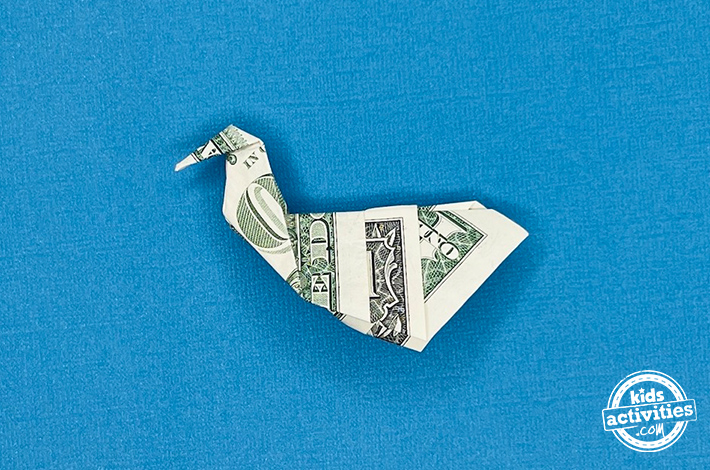 Cygne en origami en forme de billet d'un dollar - Étape 7 - Exécutez un autre pli inversé extérieur sur la pointe pour former la tête du cygne. Tutoriel du blog d'activités pour enfants.