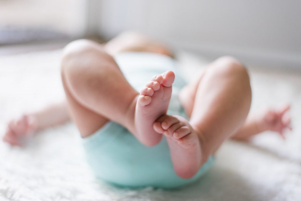 image de prénoms de bébé interdits - bébé allongé sur le dos, les pieds en l'air - Kids Activities Blog