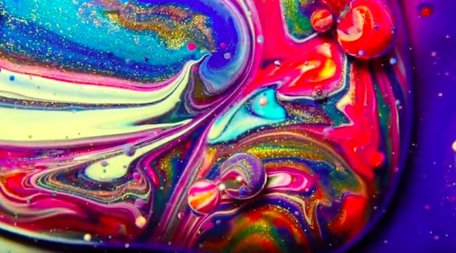 Art fascinant : tourbillons et bulles d'huile et de paillettes avec du vert, du jaune, du bleu, du rouge, du violet et du rose.
