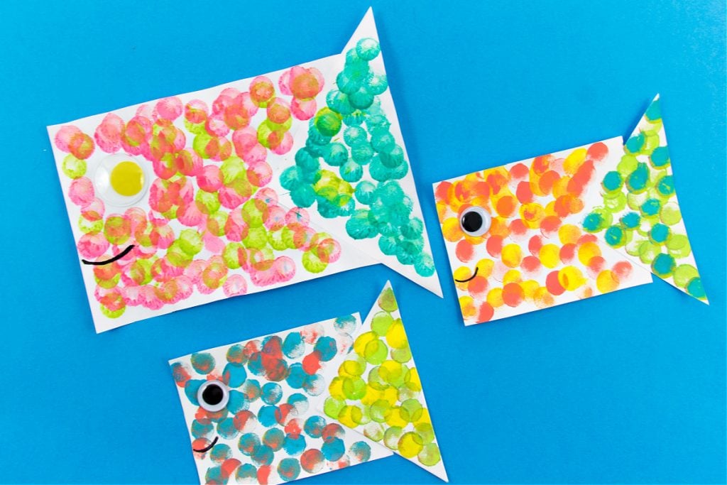 Poisson en papier coloré fait avec du papier, des yeux écarquillés et de la peinture parsemée de barbouilleurs.