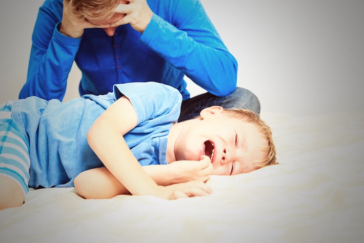 un enfant plus âgé - âgé d'environ 8 ans - en colère sous le regard frustré de son père