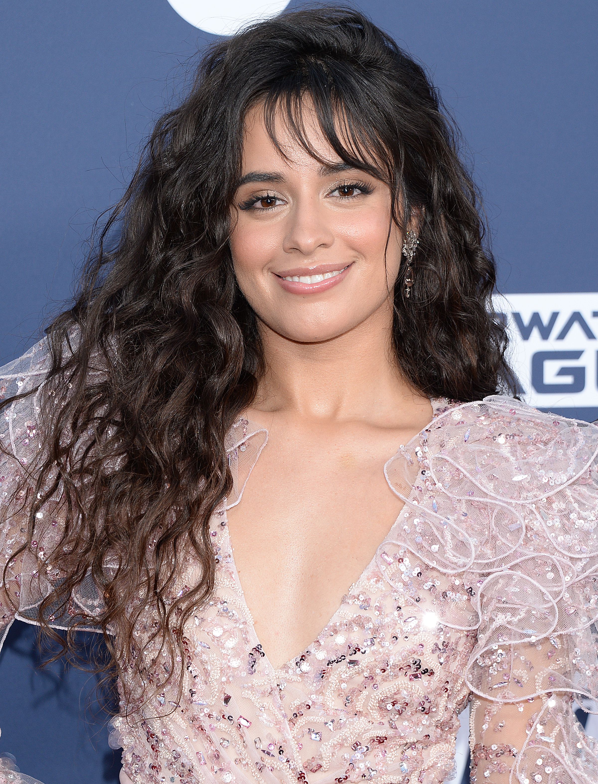 Camila Cabello porte de longs cheveux ondulés permanentés