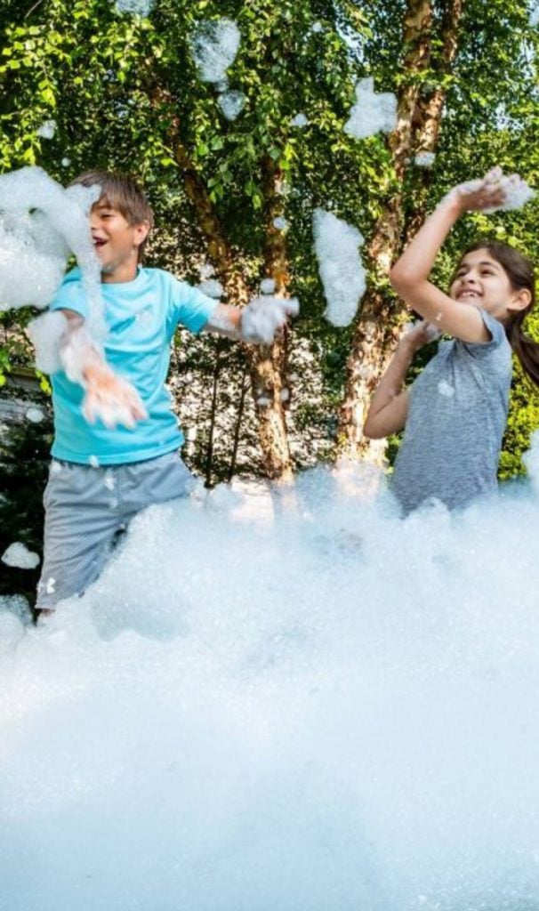 Un mur de bulles et de mousse a fait de moi un fabricant de bulles et un garçon et une fille jouant avec des bulles