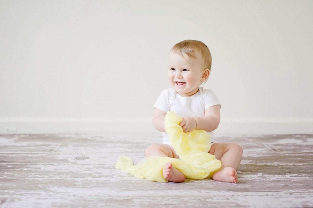 Noms de bébé des années 1990 - baby-sitting sur un plancher en bois