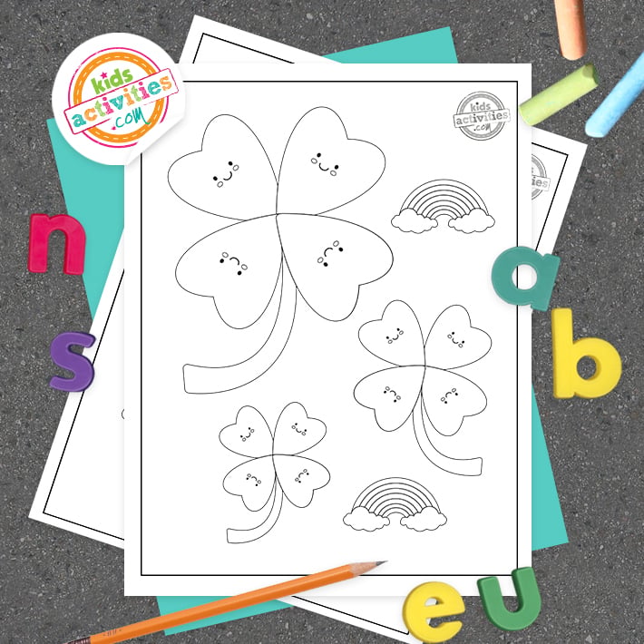 Pages de coloriage imprimables Shamrock empilées sur une table entourée de fournitures artistiques