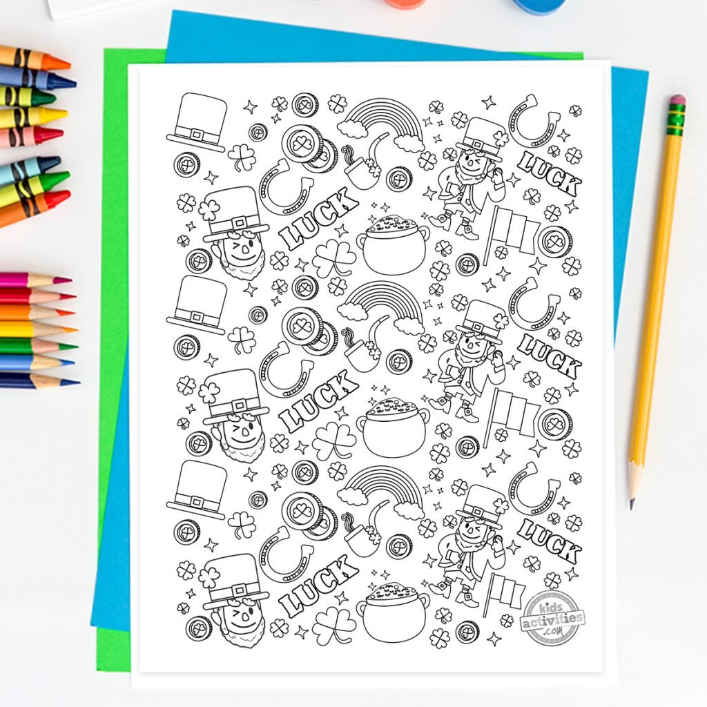 Coloriage des gribouillis de la Saint-Patrick avec lutin, arc-en-ciel, trèfles, pièces d'or, drapeau irlandais sur un bureau avec papier de couleur, crayons et crayons de couleur