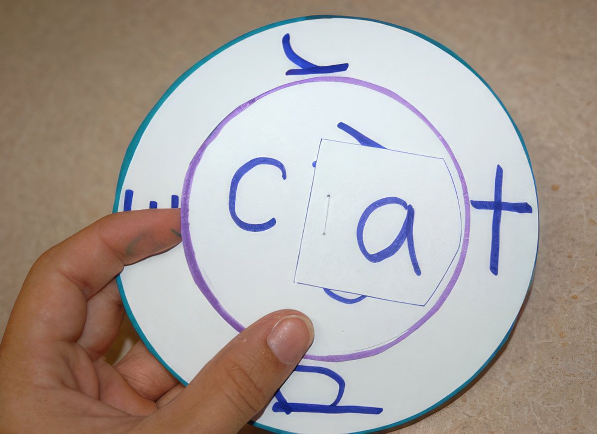 Roue de mots DIY CVC terminée pour les enfants apprenant les mots CVC présentés tenus en main avec le mot « chat »
