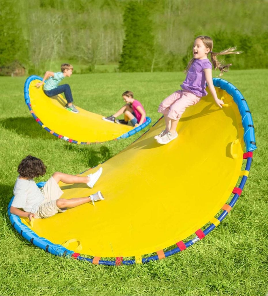 balançoire géante dans la cour avec des enfants qui jouent
