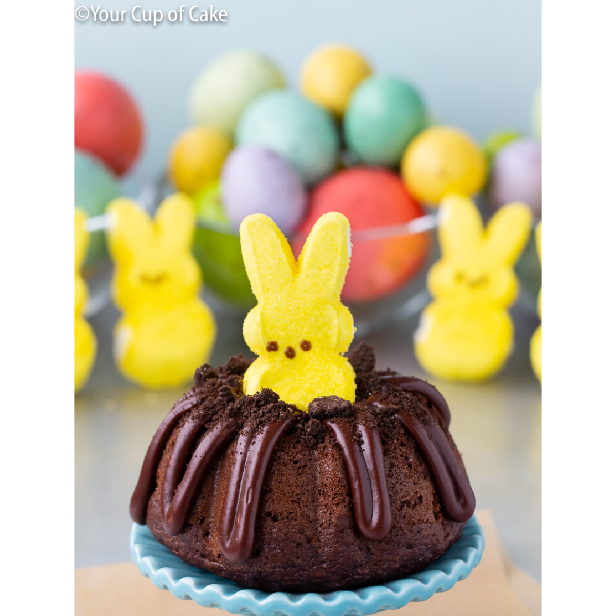 "Recette de gâteau Peeps bundt - gâteau individuel en portion individuelle avec glaçage aux couleurs de Pâques avec un lapin Peeps sur le dessus"