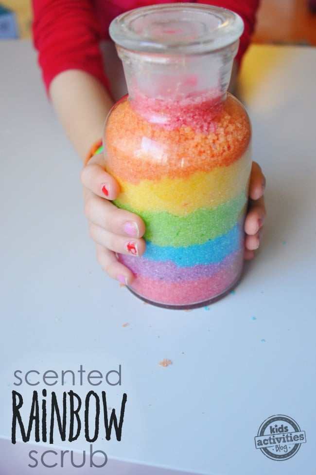 instructions de gommage arc-en-ciel - enfant tenant un gommage au sucre gommage arc-en-ciel fait maison