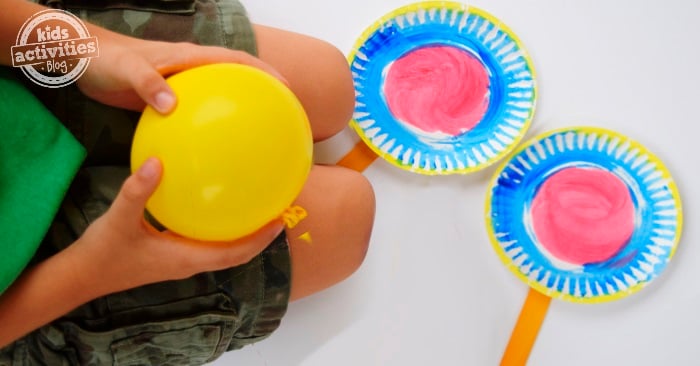 jeu de tennis en assiettes en papier - deux raquettes de tennis en assiettes en papier sur la farine avec un enfant tenant un ballon jaune - blog d'activités pour enfants