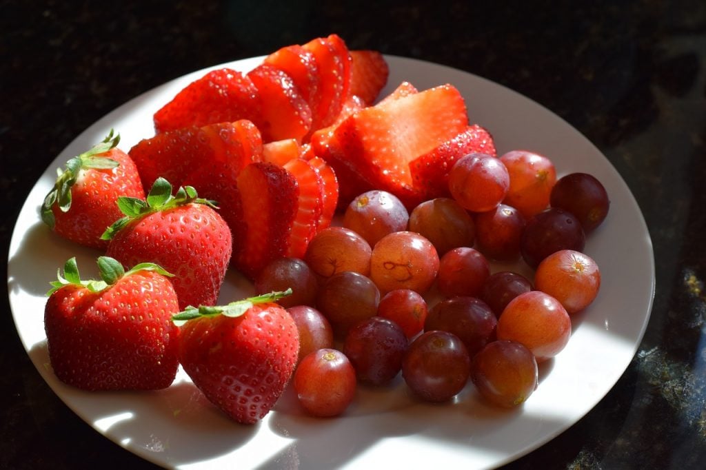 couper les fraises et les raisins sur une assiette