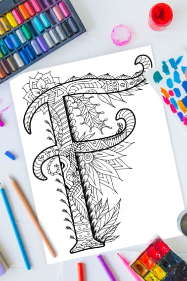 Pages à colorier de l'alphabet Zentangle - lettre f design zentangle sur fond de peinture, crayons de couleur et fournitures d'art