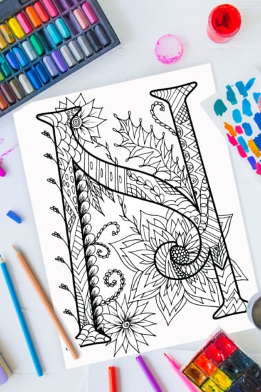 Pages à colorier de l'alphabet Zentangle - lettre n design zentangle sur fond de peinture, crayons de couleur et fournitures d'art