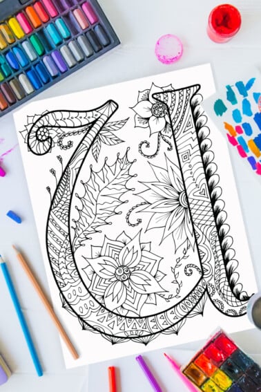 Pages à colorier de l'alphabet Zentangle - lettre u design zentangle sur fond de peinture, crayons de couleur et fournitures d'art