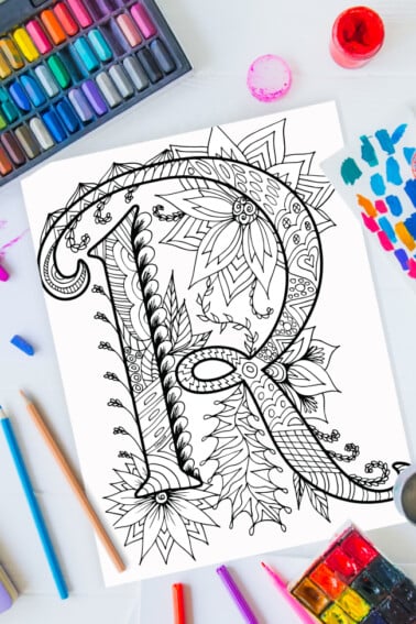Pages à colorier de l'alphabet Zentangle - lettre r design zentangle sur fond de peinture, crayons de couleur et fournitures d'art