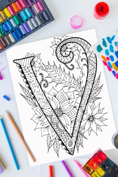 Pages à colorier de l'alphabet Zentangle - lettre v design zentangle sur fond de peinture, crayons de couleur et fournitures d'art