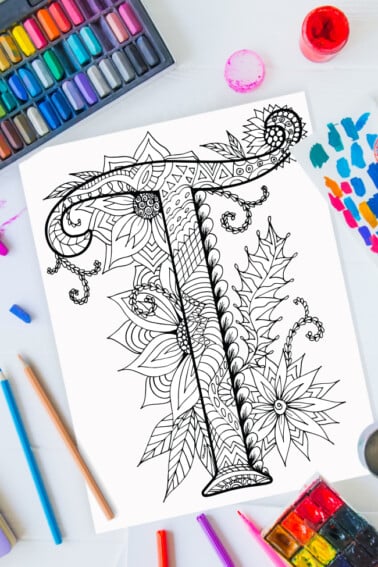 Pages à colorier de l'alphabet Zentangle - lettre t design zentangle sur fond de peinture, crayons de couleur et fournitures d'art