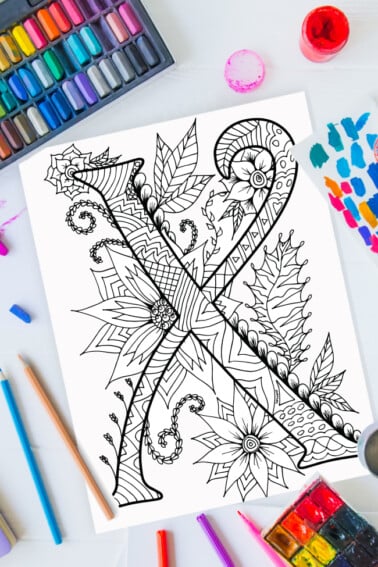 Pages à colorier de l'alphabet Zentangle - lettre x design zentangle sur fond de peinture, crayons de couleur et fournitures d'art