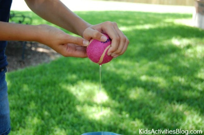 Leçon sur le cœur humain pour les enfants - pratique : une balle de tennis remplie d'eau pressée sur un seau - Kids Activities Blog