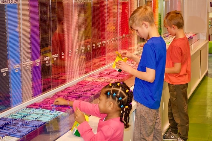 Girl and boys picking out crayola crayons for their box of crayons
