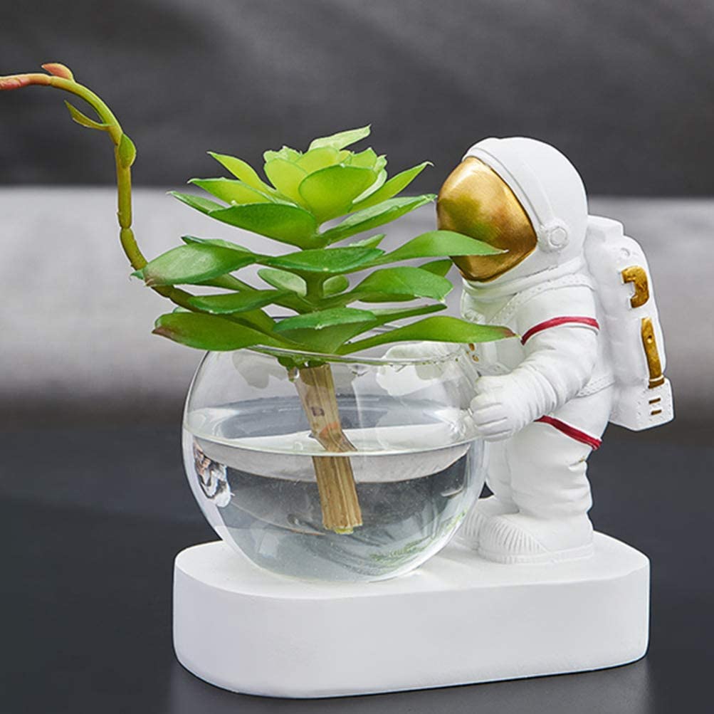 Vase astronaute blanc tenant une plante verte et de l'eau sur fond gris