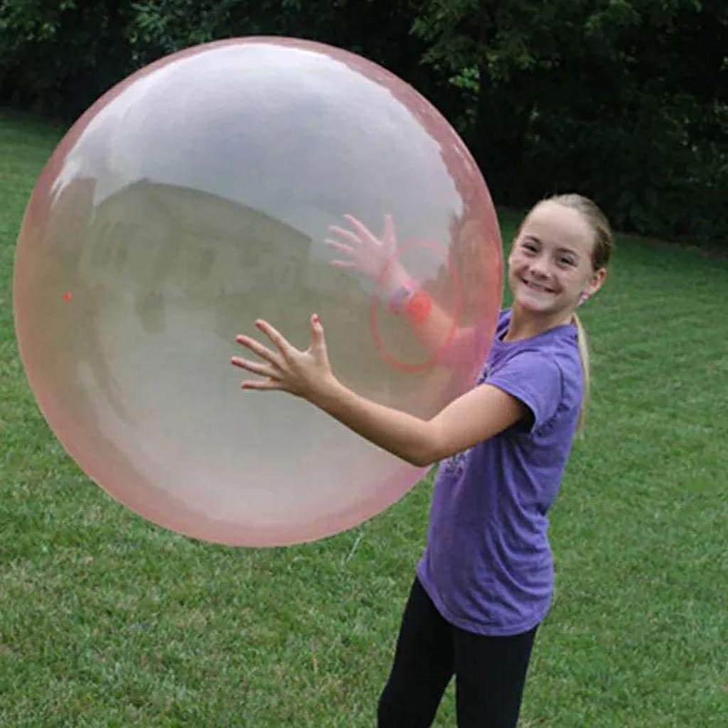 enfant tenant une boule à bulles géante remplie d'air dans une cour