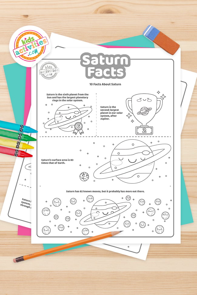 Faits amusants imprimés sur les fichiers PDF de Saturne empilés sur une table en bois entourés d'un crayon et de crayons de couleur - Kids Activities Blog
