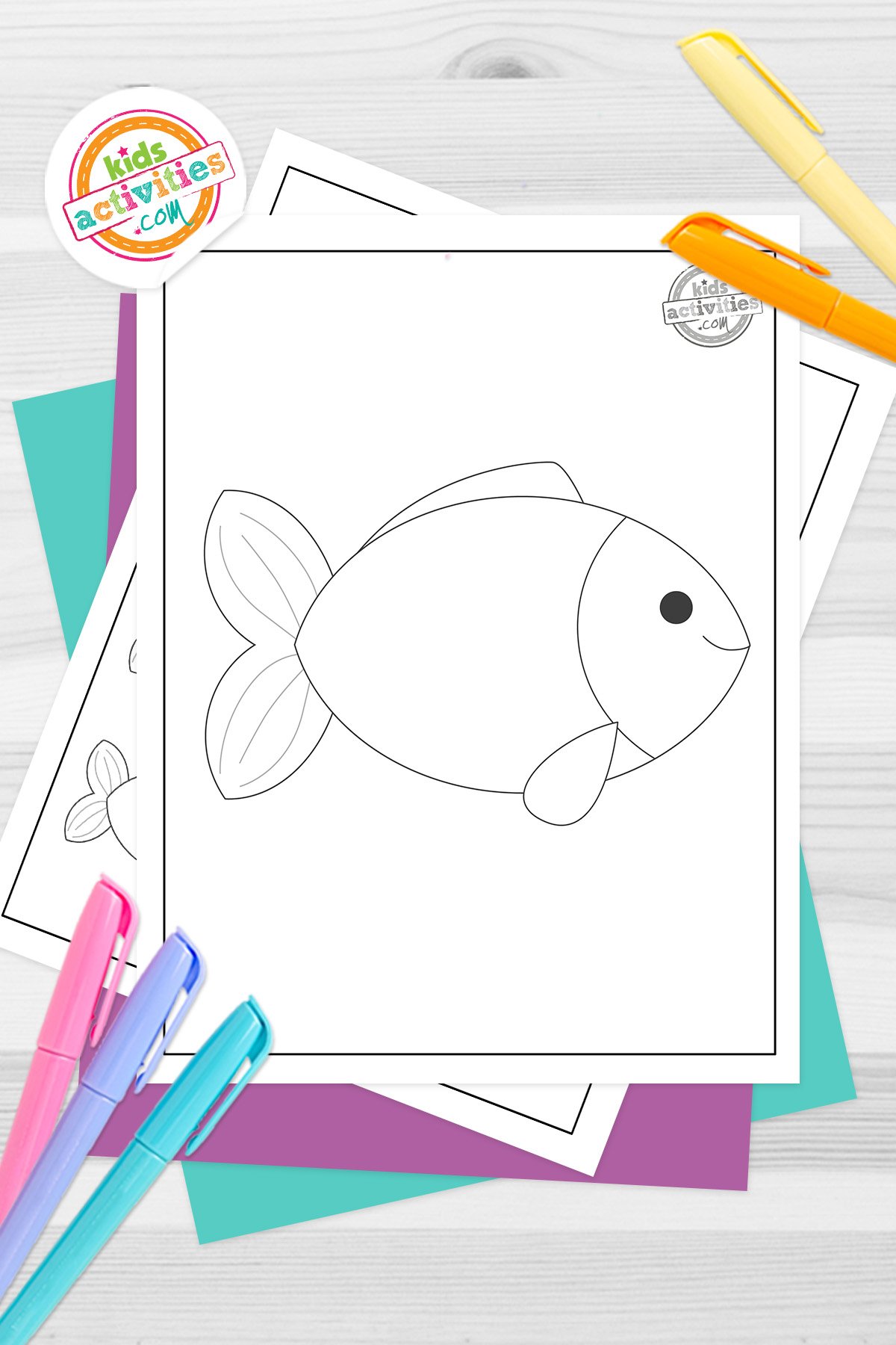 Black and white printed fish template page, made with simple lines for kids on top of blue-green and purple sheets with assorted markers on a dark grey background. printed pdf version from Kids activities blog.