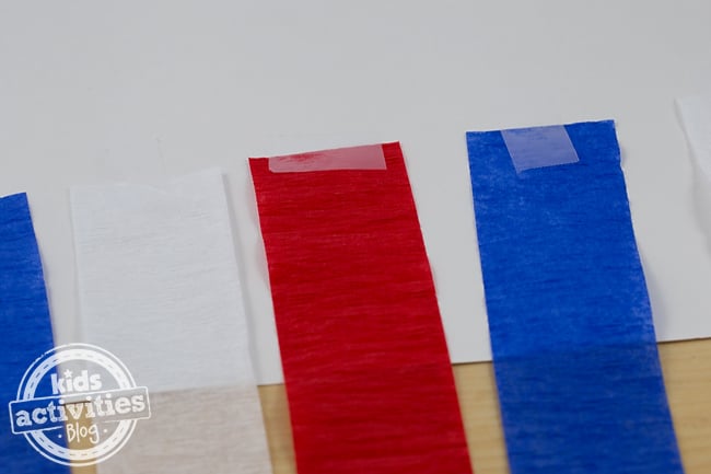 Étape 2 - Comment fabriquer une manche à air en papier patriotique - des banderoles rouges, blanches et bleues collées au dos du papier pour l'artisanat de la manche à air