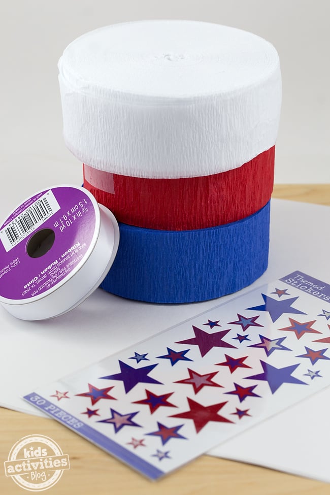 Fournitures de manche à air en papier patriotique nécessaires pour ce bricolage en papier facile : banderoles en rouge, blanc et bleu, ruban, autocollants et papier présentés - Blog d'activités pour enfants