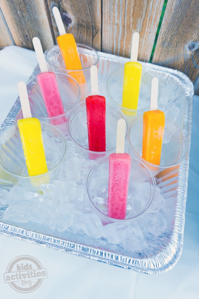 Summer Party Popsicle Bar avec des glaces pastel dans de la glace pour les fêtards à saisir dans des tasses individuelles