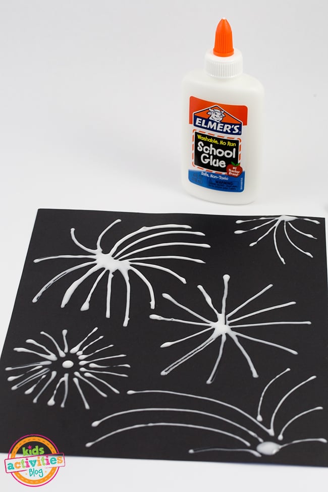 Art des feux d'artifice - Étape 1 - Tracez des lignes avec votre colle sur le papier de construction noir - Blog d'activités pour enfants.