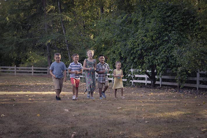 Jeu de chasse aux lucioles joué par 3 garçons et 2 filles se promenant dehors