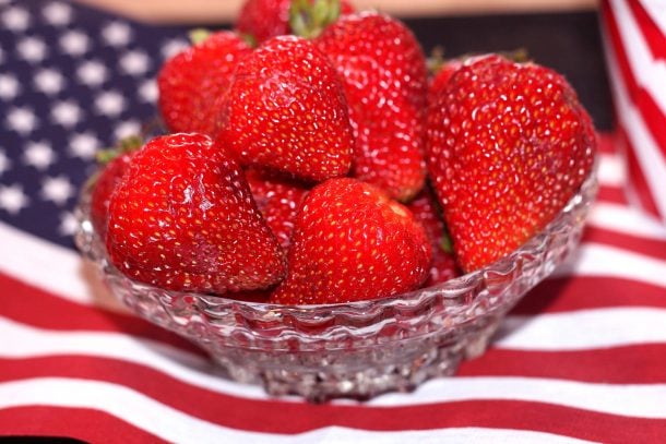 fraises fraîches dans un bol sur un drapeau américain pour le 4 juillet