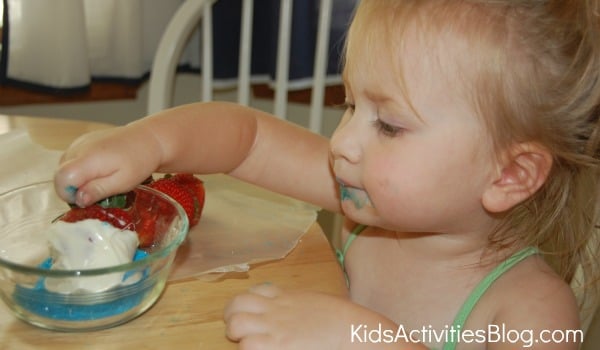 petite fille trempant des fraises
