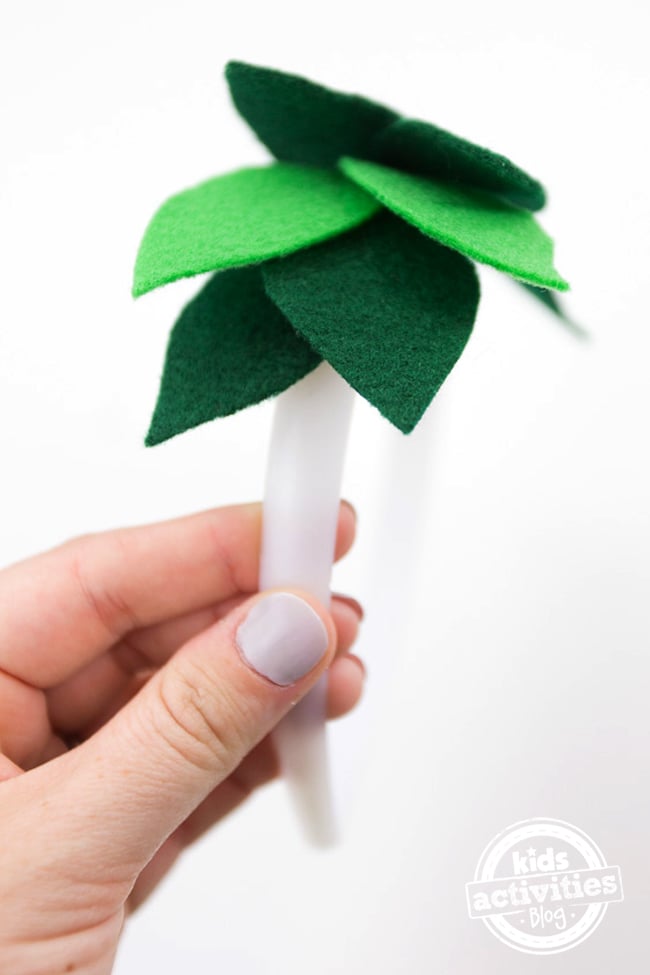 Couronne de feuilles de laurier DIY - Étape 2 - Tenez le bandeau horizontalement et commencez au milieu du dos. - Blog d'activités pour enfants