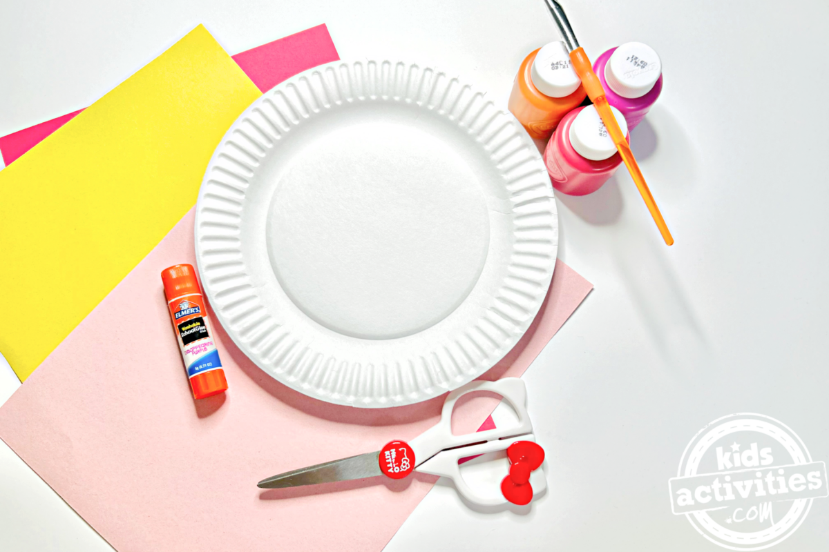 Fournitures nécessaires pour le bricolage de l'assiette en papier Donut : Peinture orange pour la pâte, n'importe quelle couleur de peinture pour le glaçage, trois couleurs différentes de papier de construction, un pinceau, de la colle et des ciseaux - blog d'activités pour enfants