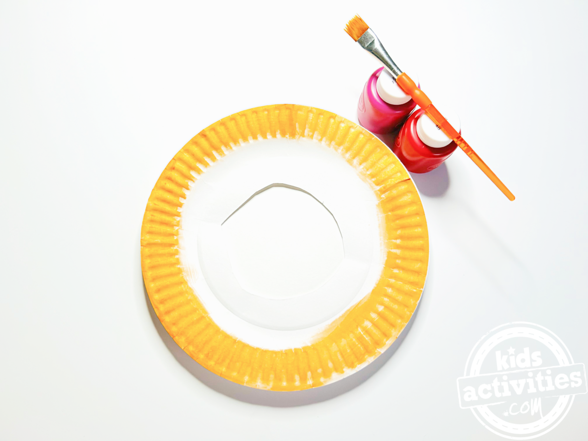 Étape 2 - Bricolage avec une assiette en papier pour beignets - Peignez l'extérieur de l'assiette en papier en orange pour la couleur de la pâte, puis peignez l'intérieur pour le glaçage - Blog d'activités pour enfants