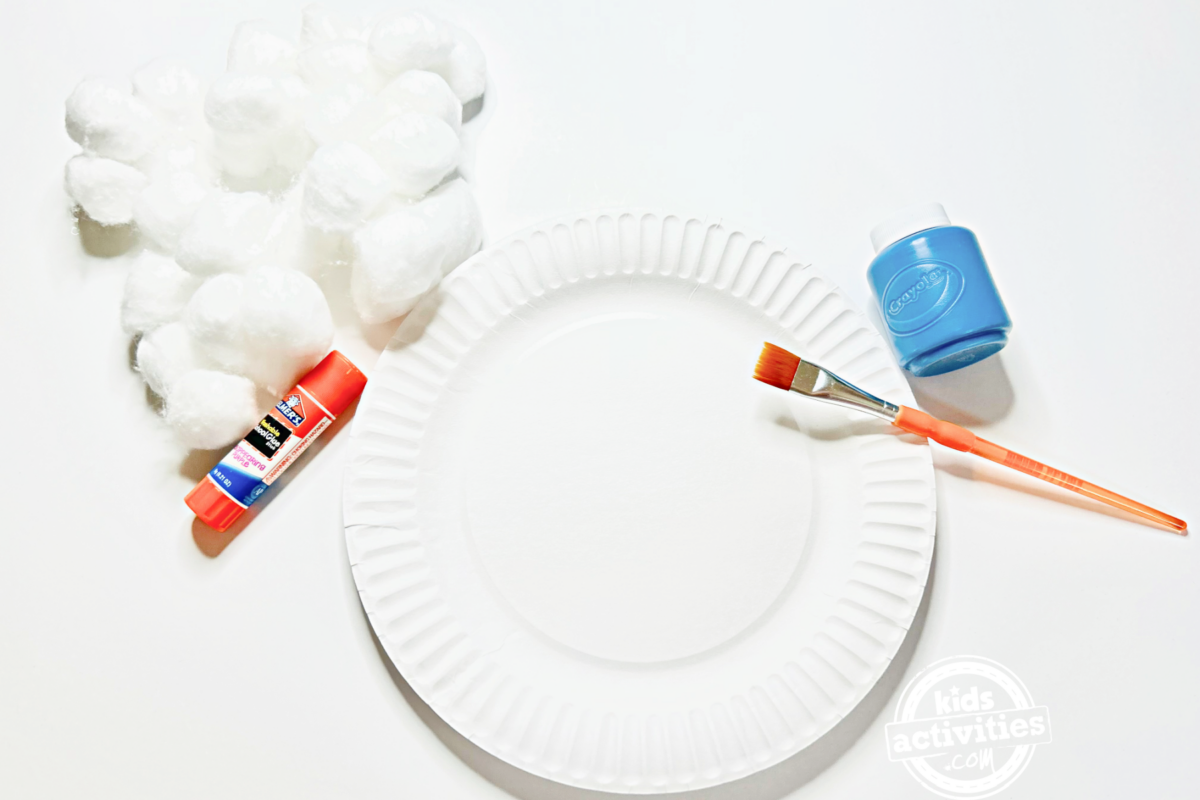 Fournitures nécessaires pour fabriquer un ciel nuageux en assiette en carton : une assiette en carton, une poignée de boules de coton, de la colle, un pinceau, de la peinture bleue - blog d'activités pour enfants