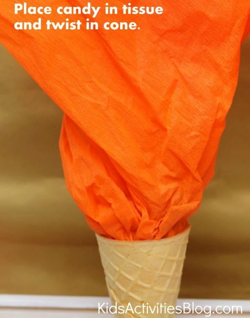 Torches olympiques comestibles à faire soi-même - Étape 1 - Enveloppez les bonbons dans du papier de soie et tordez-les dans le cornet de crème glacée. - Blog d'activités pour enfants