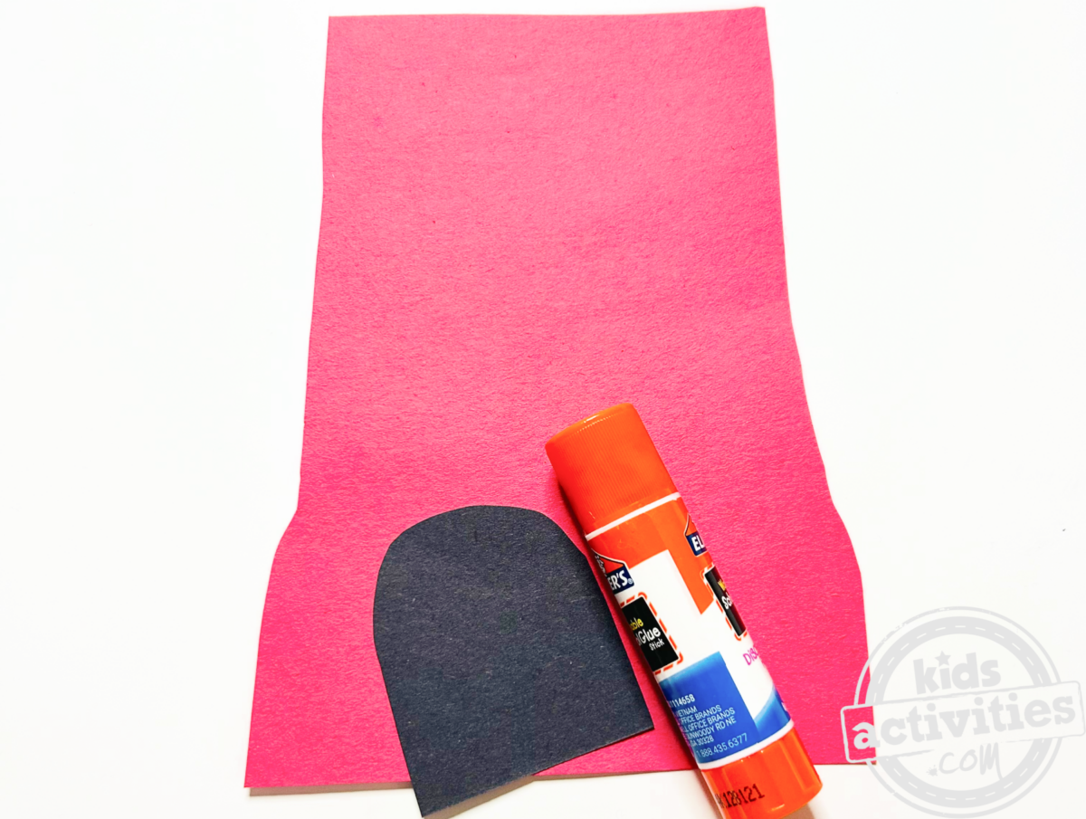 Étape 2 - Bricolage avec une assiette en papier pour une machine à boules de gomme - Découpez une base rouge pour votre machine à boules de gomme et un demi-cercle noir pour l'endroit où sortent les boules de gomme, puis collez la pièce noire sur le fond - Blog d'activités pour enfants