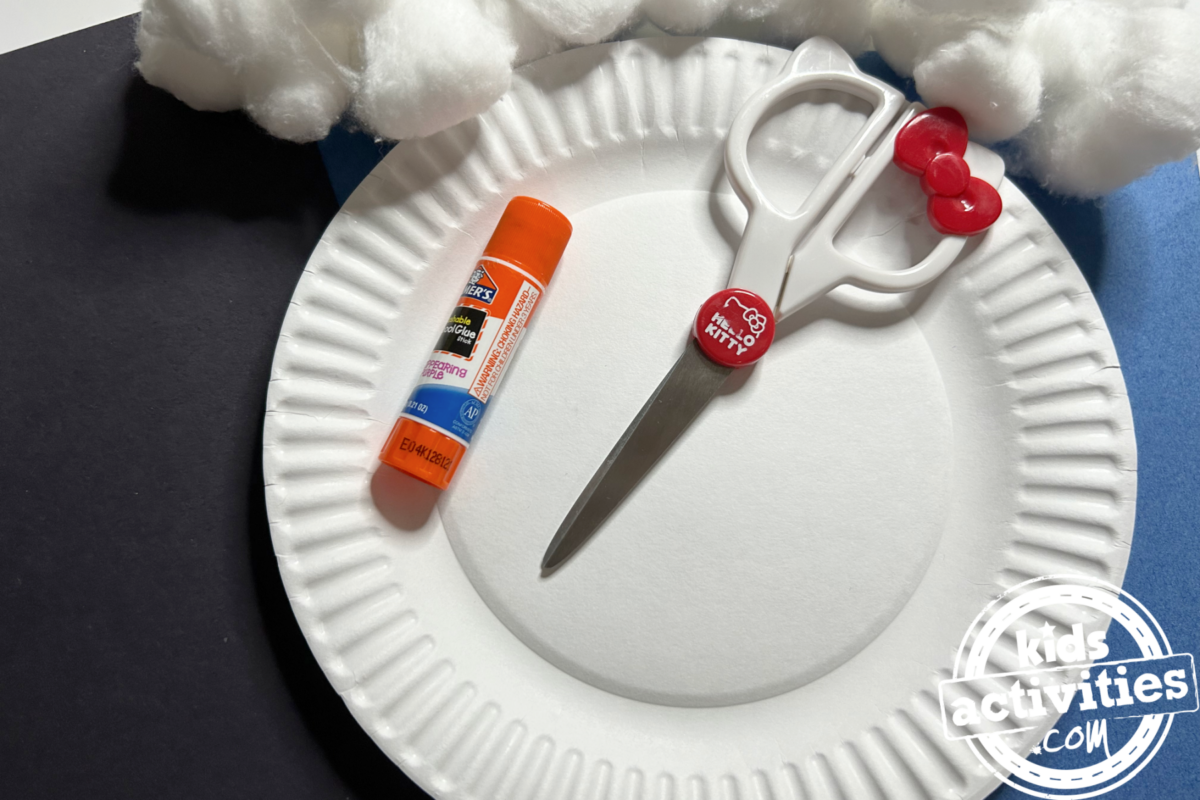 Fournitures nécessaires pour fabriquer un igloo en assiette en carton : une assiette en carton, du papier de construction noir, des boules de coton, de la colle, des ciseaux - Blog d'activités pour enfants