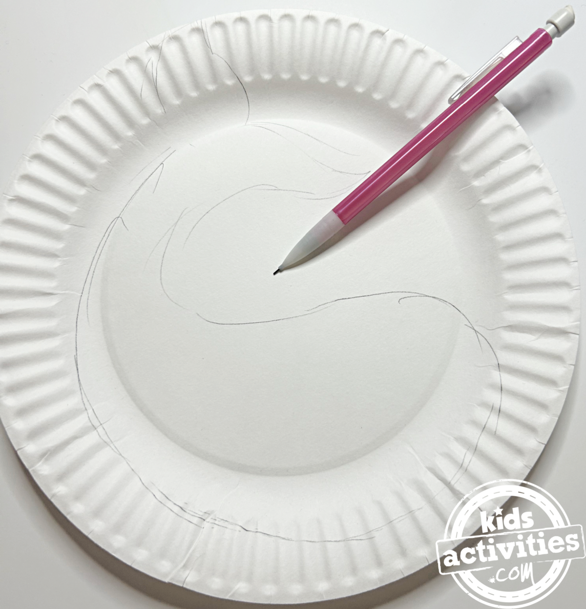 Étape 1 - Bricolage avec une assiette en carton pour narval - Dessinez la forme du narval avec un crayon sur votre assiette en carton - Blog d'activités pour enfants