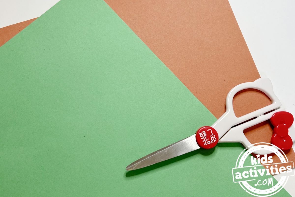 Étape 2 - Bricolage avec une assiette en papier orange - Découpez le papier de construction vert en forme de petite feuille, puis découpez une petite forme de tige avec le papier de construction marron - Blog d'activités pour enfants